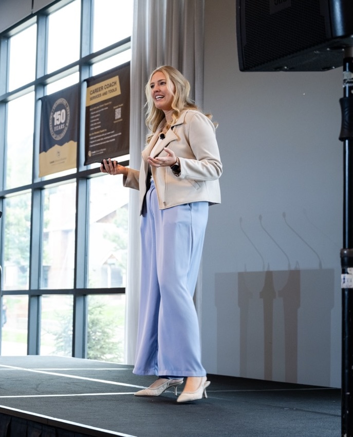 Kate Strohl speaking on stage at a conference